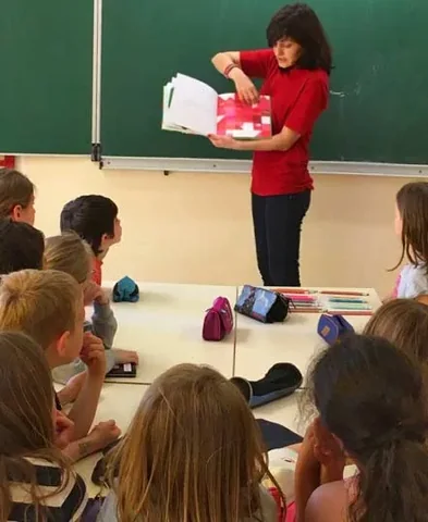 Denitza Mineva presenting a book to a class